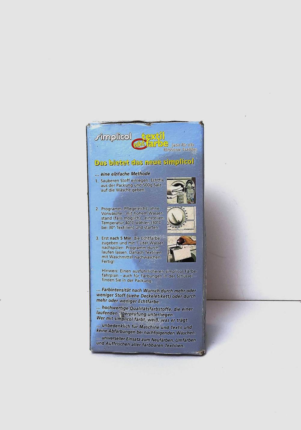 Auf der Seite der Kartonverpackung von getesteter Textilfarbe schwarz steht die bebilderte Anleitung.