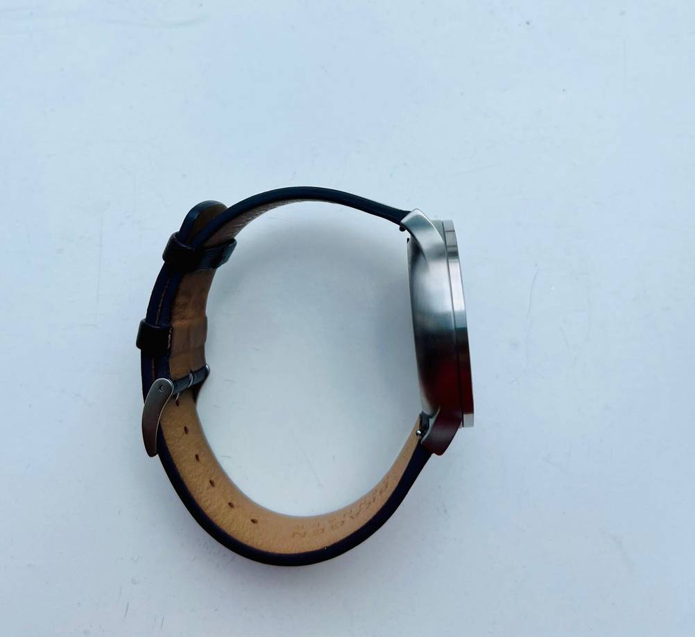 Getestet: Eine Skagen-Uhr mit geschlossenem Armband von der Seite auf einer hellen Fläche.