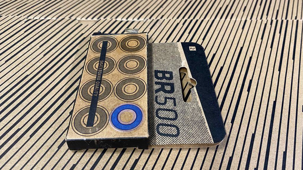 Getestete Kugellager für Skateboards befinden sich verpackt auf einer Holzoberfläche.