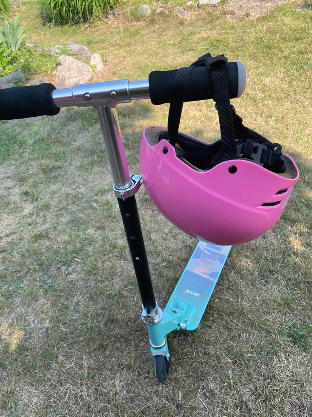 An einem Roller hängt ein getesteter Skaterhelm für Kinder.