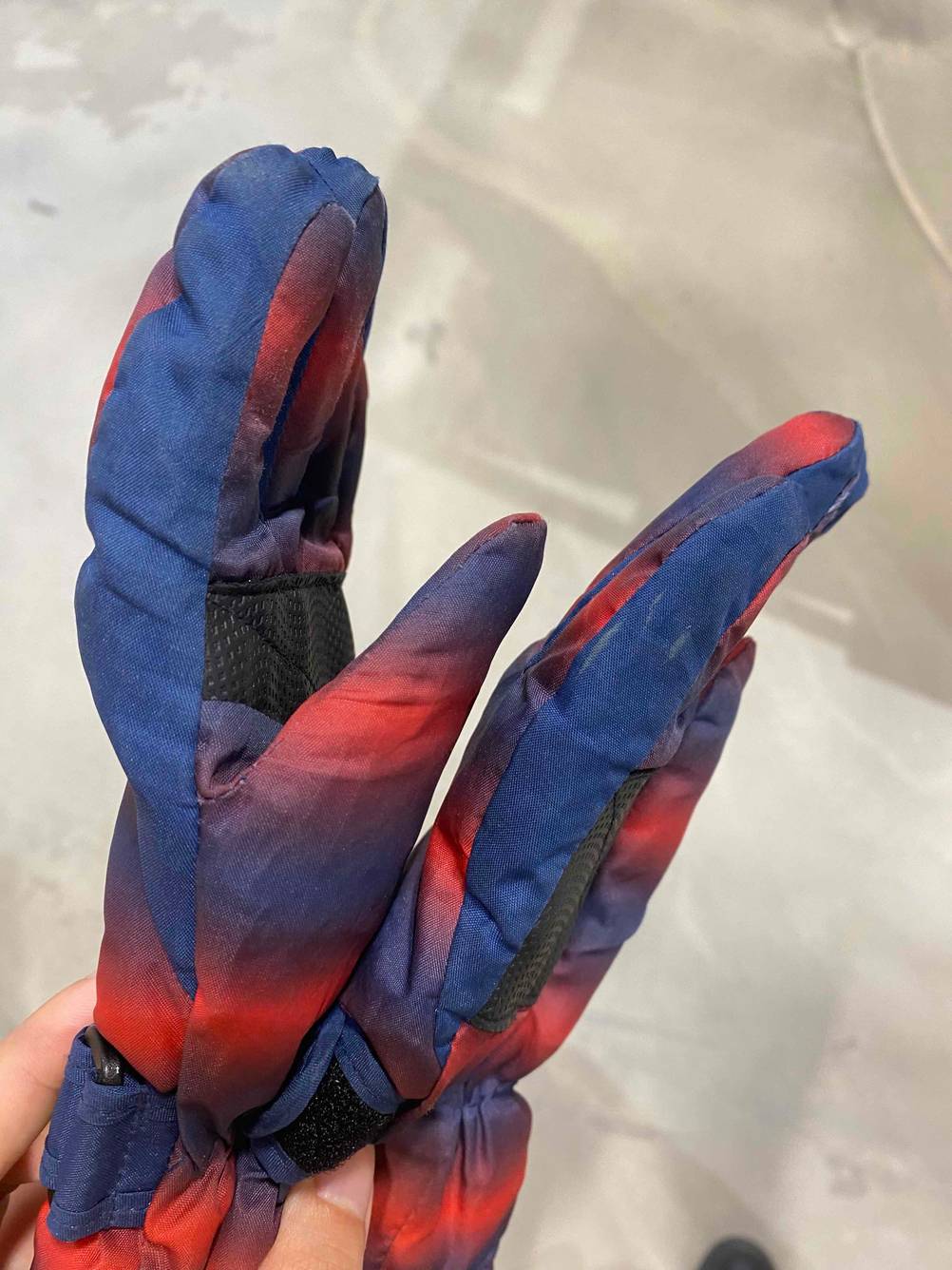 Eine Hand hält ein Paar getestete Skihandschuhe für Damen.