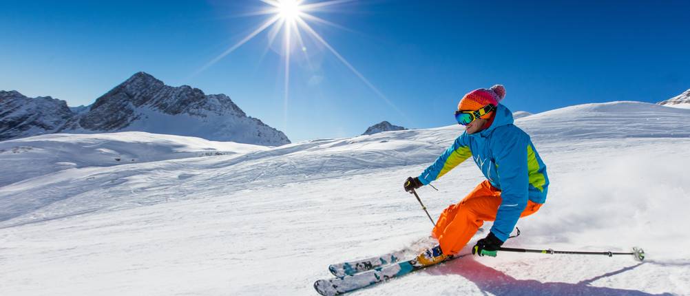 Skifahrer in Skihose bei der Abfahrt