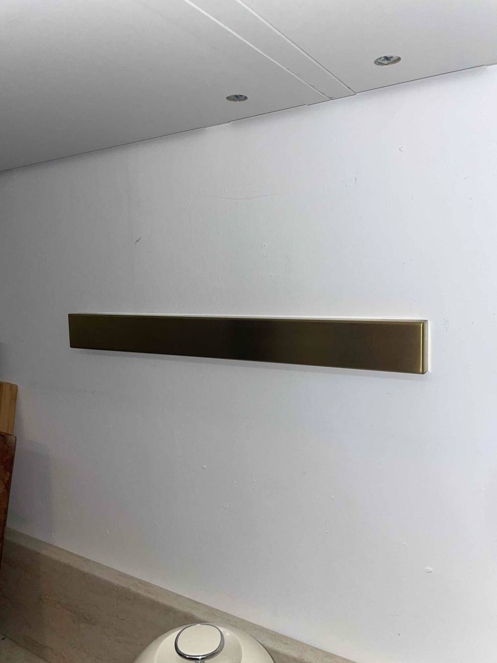 Eine Magnetleiste für Messer ist zum Testen an einer weißen Wand montiert.