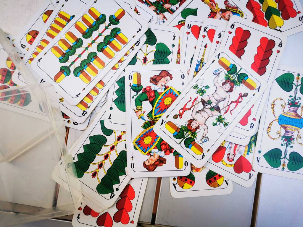 Ein Pack Schafkopfkarten liegt zum testen ausgebreitet auf einem Tisch.