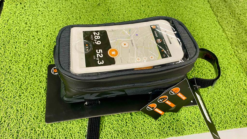 Im Test: Eine Fahrrad-Rahmentasche Handy liegt quer auf einem grünen Kunstrasen.