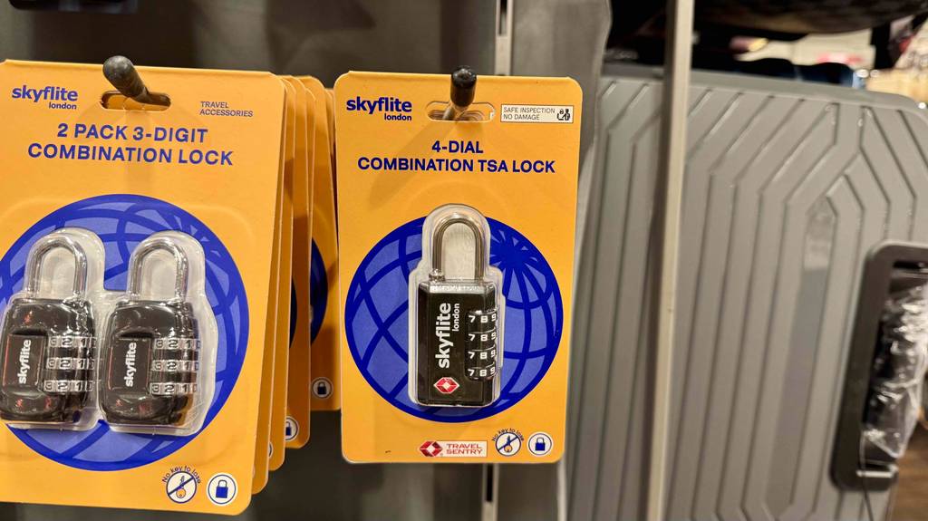 Kofferschloss getestet: Mehrere original verpackte Zahlenschlösser von Skyflite hängen an einem Verkaufsregal.