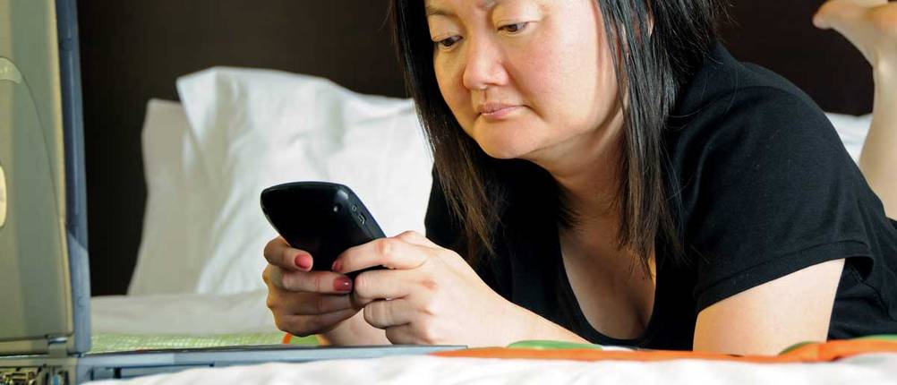 Asiatische Frau mit BlackBerry-Handy