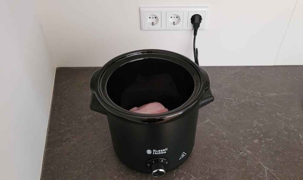 Slow-Cocker-Test: Ein schwarzer Slow-Cooker von Russel Hobbs wird an einer Steckdose aufgeladen. 