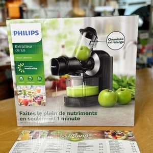 Der Philips HR1889/70 Slow Juicer in seiner Originalverpackung. Der Karton steht auf einem Tisch mit einer Menükarte davor.