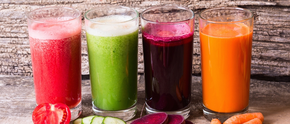 Slow-Juicer-Test: 4 Gläser mit unterschiedlichen Gemüsesäften (Tomate, Gurke, Rote Beete, Karotte)