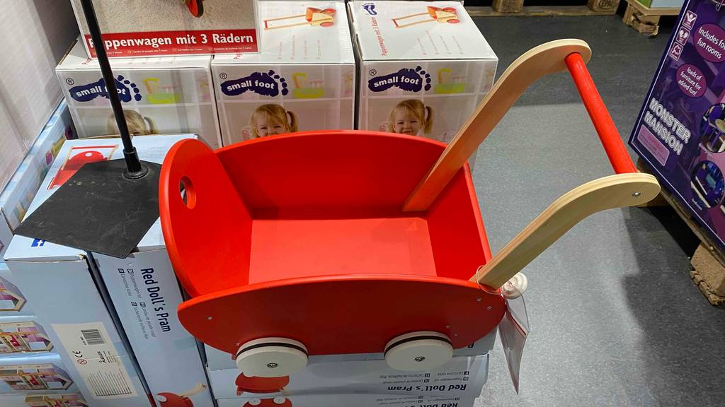 Getesteter Puppenwagen aus Holz befindet sich auf einigen Kartons.