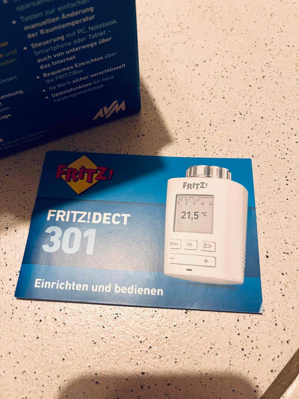 Smart-Home-Heizkörperthermostat getestet: Die Bedienungsanleitung neben der Verpackung auf einer hellen Fläche.