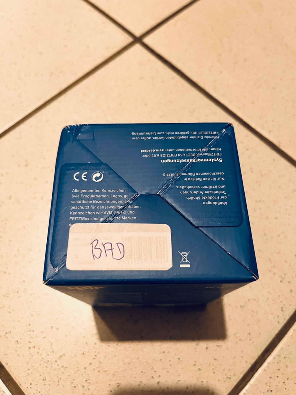 Der Boden einer Verpackung des getesteten Smart-Home-Heizkörperthermostats auf einem Fliesenboden.