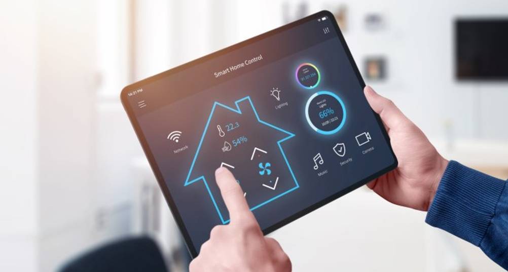 Lüfterlose Mini-PCs im Test: Ein Mann hält ein Tablet mit Smart-Home-Daten in der Hand.