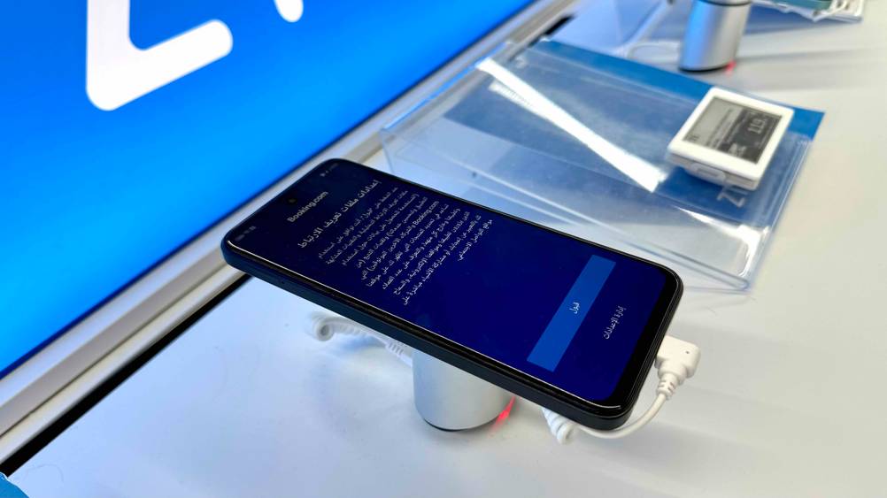 Seitenansicht des getesteten Smartphone bis 150 Euro auf einem Ständer auf einem Verkaufsregal.