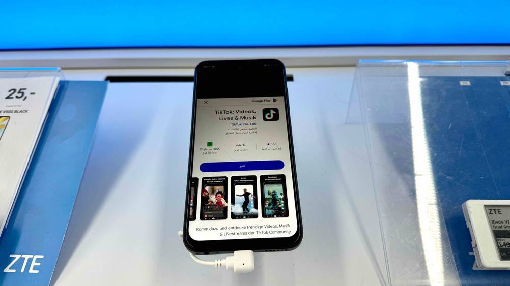 Das getestete Smartphone bis 150 Euro auf einem Ständer in einem Verkaufsregal.