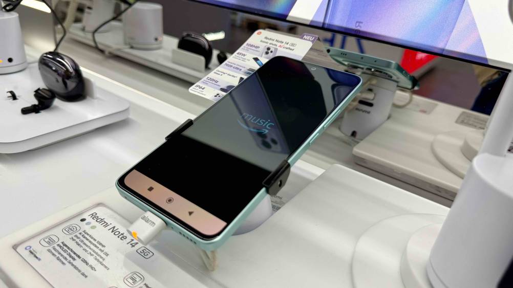 Seitenansicht des getesteten Smartphone bis 350 Euro auf einem Ständer mit Informationen.