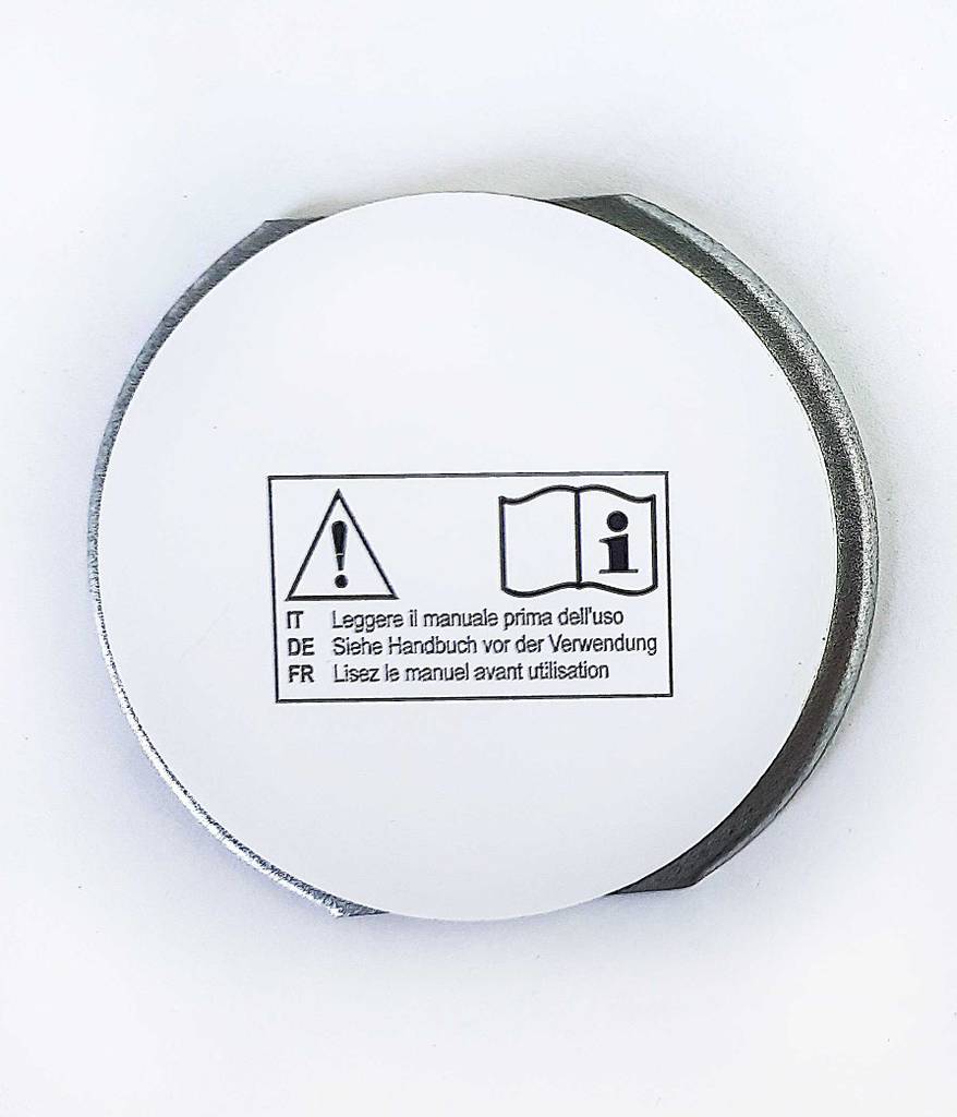 Auf einem Teil eines getesteten Rauchmelder-Magnethalters sind Warnhinweise.