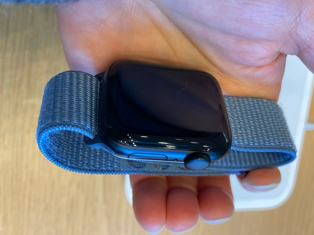 Im Test: Eine Hand hält eine Smartwatch mit blauem Band.
