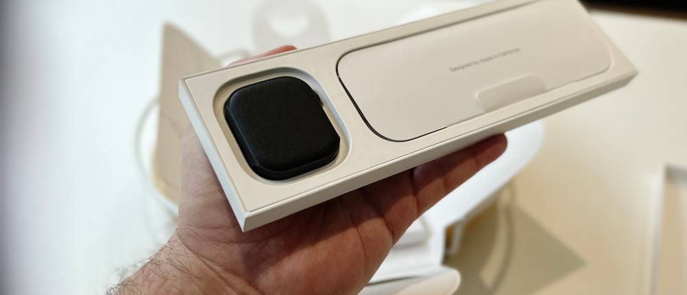 Die Person zeigt den Inhalt der kompletten Zubehörbox, die zur Apple Watch Series 11 gehört.