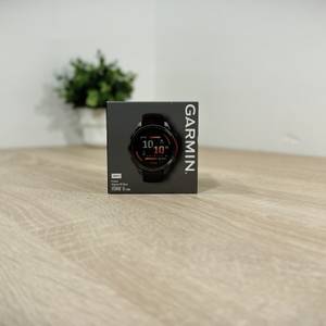 Auf einem Holztisch liegt die Garmin Fenix ​​8 in ihrer Schachtel.