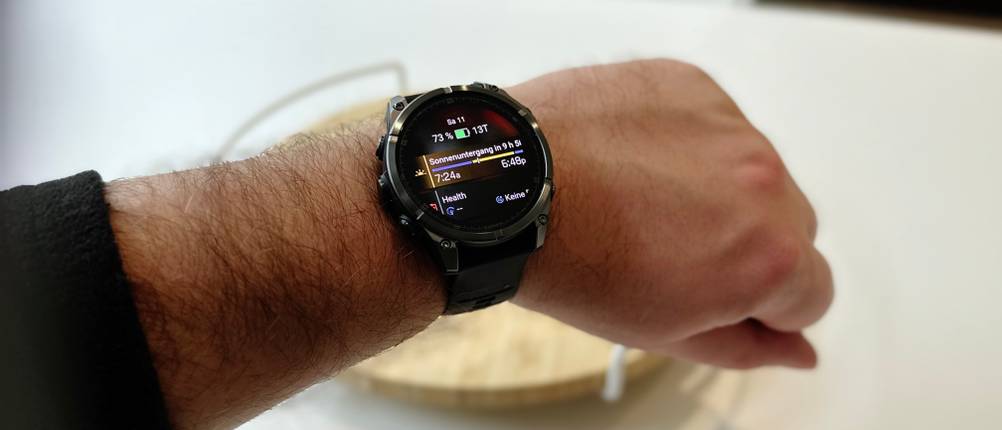 Die Person trägt die Gamin-Fenix-8-Smartwatch und demonstriert die Helligkeit und Lesbarkeit des Bildschirms.