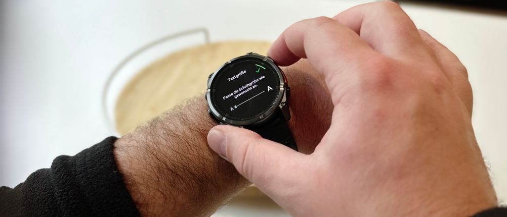 Die Person stellt die Textgröße ihrer Garmin-Fenix-​​8-Smartwatch ein, während sie diese am Handgelenk trägt.