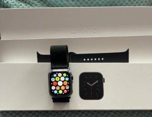 Eine schwarze Smartwatch mit Armband in einer Verpackung. 