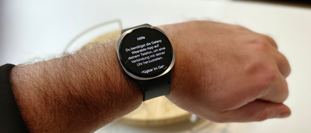 Die Person trägt eine Samsung-Galaxy-Watch-8-Smartwatch und zeigt die Hilfefunktion der Smartwatch an.