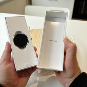 Die Person zeigt die geöffnete Schachtel und das darin befindliche Gehäuse der Samsung-Galaxy-Watch-8-Smartwatch.