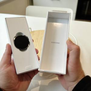 Die Person zeigt die geöffnete Schachtel und das darin befindliche Gehäuse der Samsung-Galaxy-Watch-8-Smartwatch.