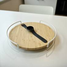 Die Samsung Galaxy Watch 8 liegt auf einem Bambus-Holzbrett, welches auf einem weißen Küchentisch liegt.