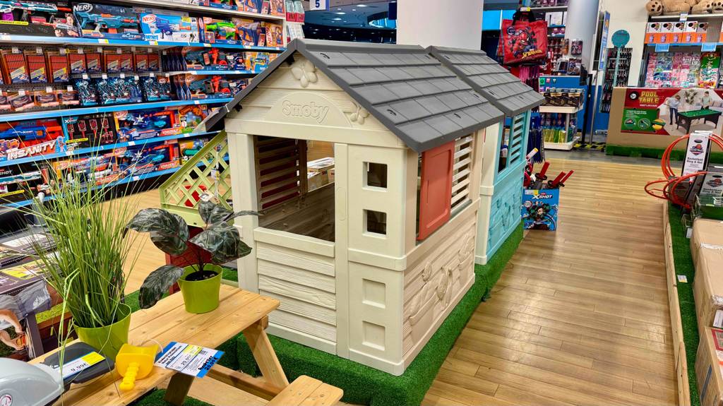 Spielhäuser getestet: Zwei farbige Kunststoffhäuser für Kinder sind nebeneinander in einem Spielwarengeschäft ausgestellt.