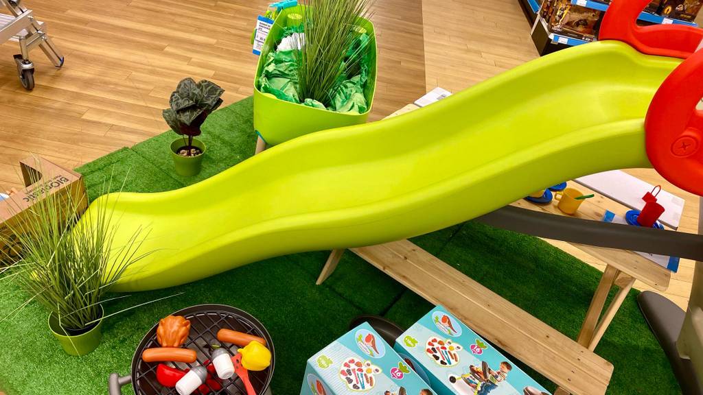 Gesamtansicht der langen hellgrünen Kunststoffrutsche einer Kinderrutsche im Test.