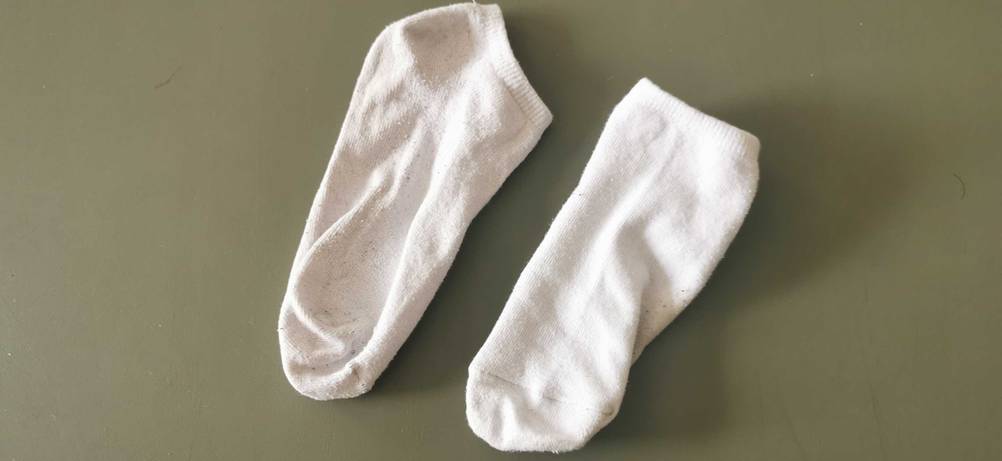 Im Test: Ein paar weiße Sneaker-Socken auf einer dunklen Fläche.