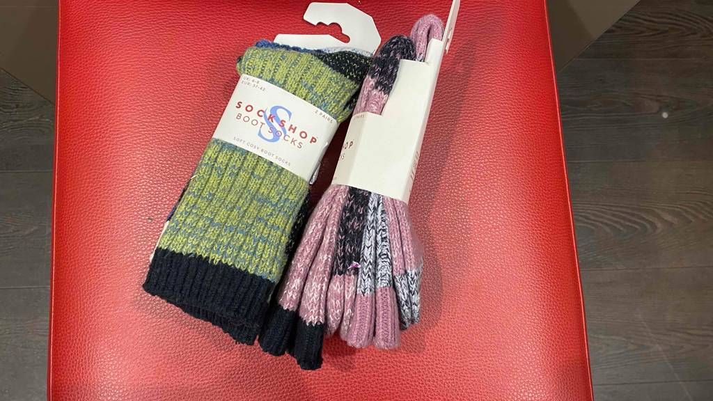 Wintersocken im Test: neue Socken im Zweierpack befinden sich auf einer roten Oberfläche.
