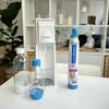 Der SodaStream Cool mit zwei PET-Flaschen und einem CO₂-Zylinder auf einem weißen Tisch.