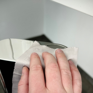 Eine Hand wischt mit einem Mikrofasertuch über die Edelstahl-Oberfläche des SodaStream Enso.