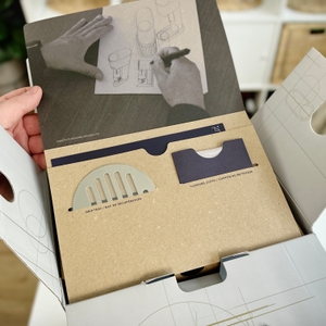 Die geöffnete Verpackung eines SodaStream Enso zeigt eine durchdachte Anordnung mit separatem Zubehörfach und Designelementen.