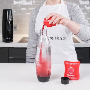 Zugabe eines Sirups in eine kohlensäurehaltige Flasche.