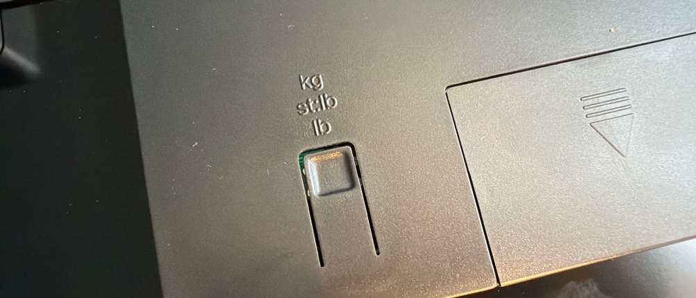 Ein Knopf auf der Rückseite der Soehnle Style Sense Safe 300 ist mit verschiedenen Einheiten für Gewichte beschriftet.