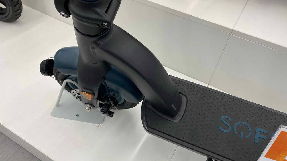Vorderreifen und Trittfläche im Detail eines getesteten E-Scooters mit 500 Watt, der auf weißem Boden steht.