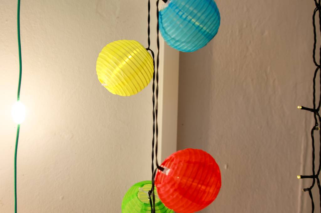 Solar-Lichterkette-Test: Lampions-Lichterkette vor Wand.
