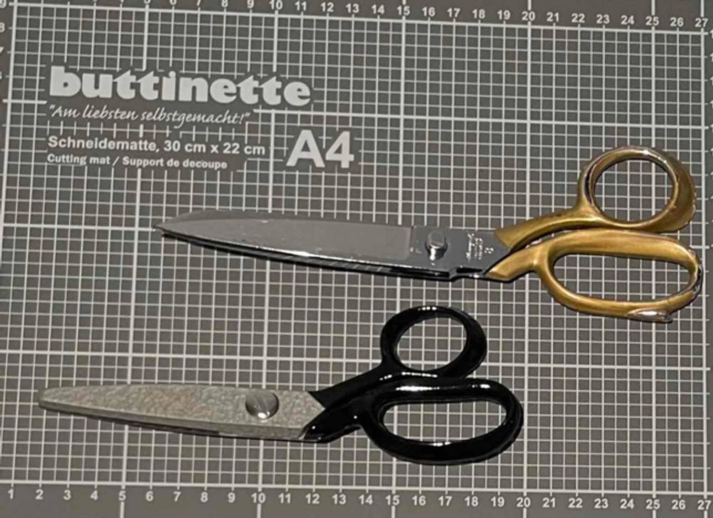 Schneiderscheren-Test: zwei Stoffscheren liegen nebeneinander auf einer Schneidematte von Buttinette.