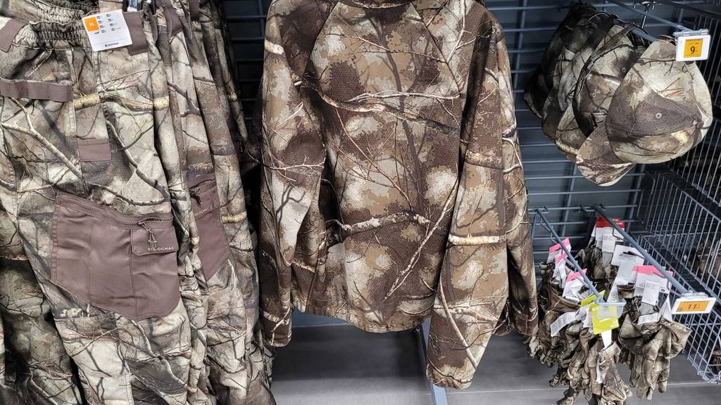 Eine getestete Jagdjacke für Damen im Camouflage-Design hängt an einem Verkaufsstand.