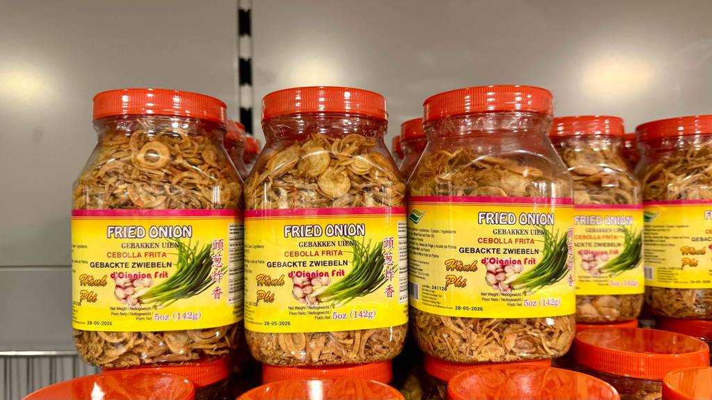 Röstzwiebeln im Test: Mehrere Gläser stehen auf-, neben- und hintereinander in einem Regal.