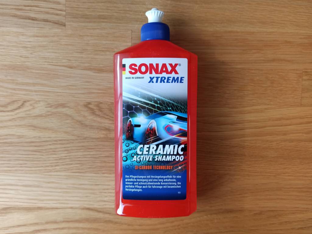 Eine Packung Autoshampoo liegend auf einem Untergrund aus Holz