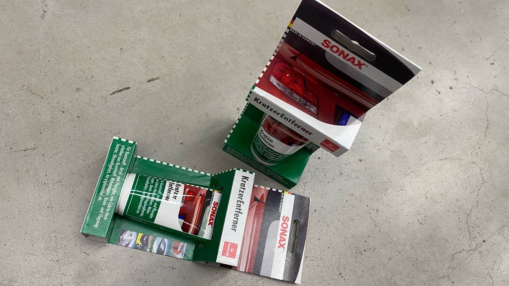 Zwei Verpackungen Sonax-Auto-Kratzer-Entferner im Test befinden sich auf einem Boden.