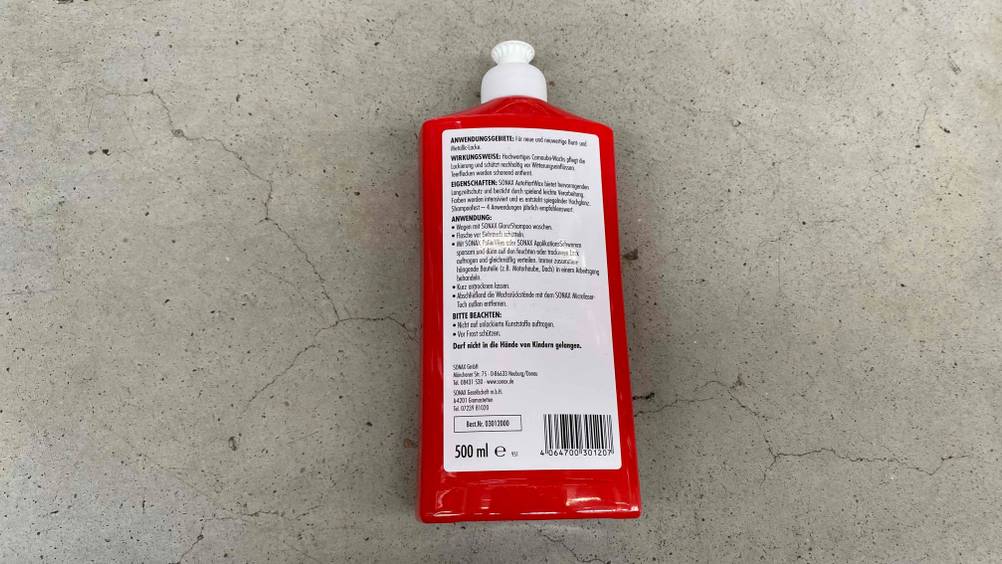 Die Rückseite einer Flasche getesteten Auto-Hartwachses auf einem Betonboden.