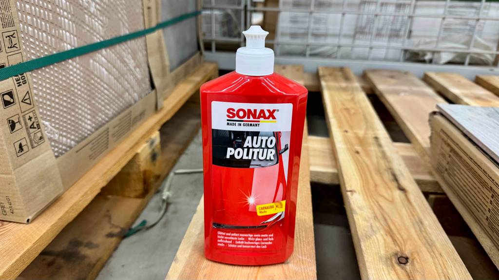 Eine Flasche Sonax-Politur steht zum testen auf einer Holzpalette.